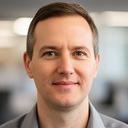 Operations director portrait in a UK office with a calm professional expression